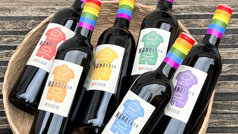 Unique and organic - Pride wines, © Stefan Jurecek Six wine bottles with rainbow labels in a basket on a wooden table.