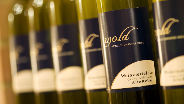 Weinflaschen, © Himml Nahaufnahme von Weinflaschen mit Etikett 'Mold Weingut Johannes Mold'.