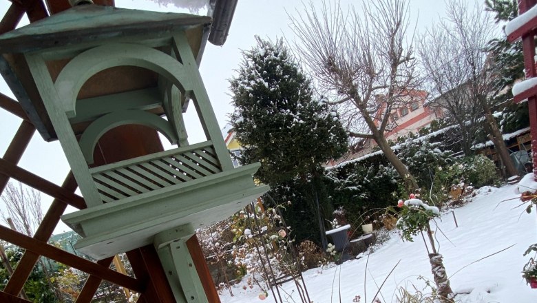 Winterstimmung, © Michaela Wannemancher Verschneiter Garten mit Vogelhaus und Teich.