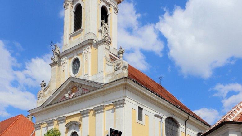 Augustiner Kirche, © Stadtgemeinde-Korneuburg Barocke Kirche mit Turm und Uhr vor blauem Himmel.