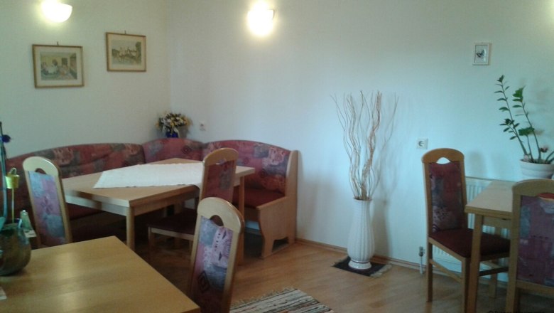 Sitzgelegenheiten in der Gemeinschaftsküche, © © Bianca Waysmayer Gemütliche Sitzecke in einer Gemeinschaftsküche mit Holztischen und gepolsterten Stühlen.