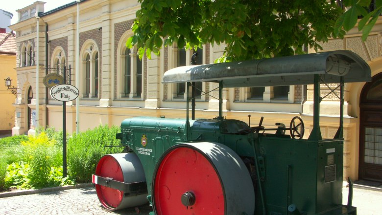 Siegfried Marcus Automobile Museum, © Stadtgemeinde Stockerau Historic steamroller in front of a building with the inscription 'Siegfried Marcus Platz'.