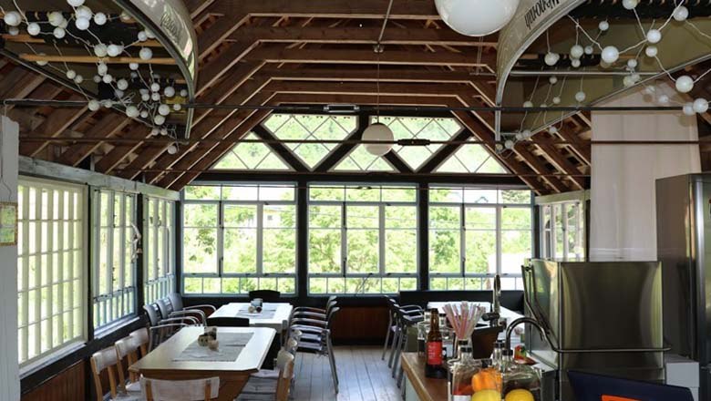 Hauser's Hölzelmühle, © Fam. Hauser Innenansicht eines hellen Raumes mit Holzdach und großen Fenstern.