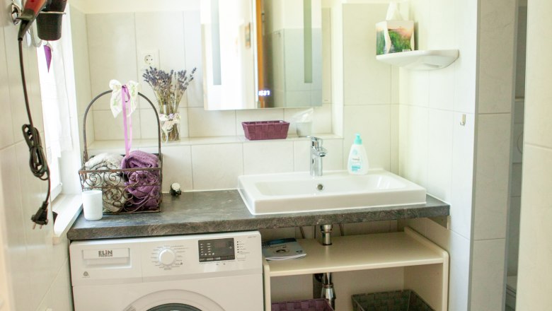 Badezimmer, © Michael Sokolar Modernes Badezimmer mit Waschmaschine, Waschbecken und Spiegel.