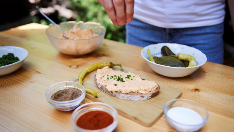 Liptauer bread, © Ben Leitner Liptauer bread on a wooden board, surrounded by spices and pickled vegetables.