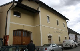 Außenansicht der Schaumühle, © Gemeinde Schrattenberg Außenansicht eines gelben Gebäudes mit der Aufschrift 'Schaumühle'.