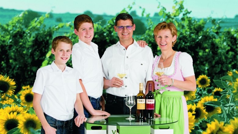 Familie Vock, © Franz Vock Familie mit Weinflaschen und Sonnenblumen im Hintergrund.