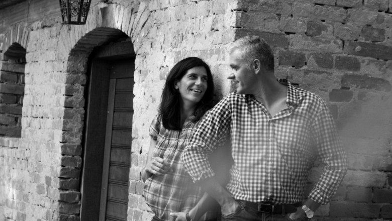 Zirnsack Winery, © Weingut Zirnsack A man and a woman lean against a brick wall, smiling.
