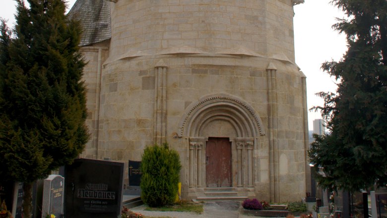 Karner Pulkau, © Fotoclub Pulkau Karner Pulkau, ein historisches Gebäude mit spitzem Dach, umgeben von einem Friedhof.