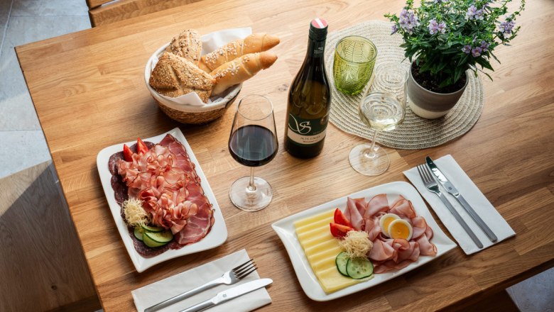 Regionale Köstlichkeiten liebevoll zubereitet, © Martin Mathes Ein Tisch mit regionalen Köstlichkeiten: Aufschnitt, Käse, Brot, Rot- und Weißwein.