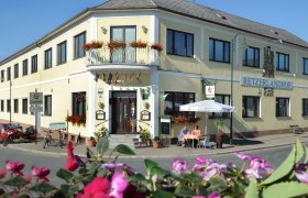Retzerlandhof, © Herbert Schleich Außenansicht des Retzerlandhofs mit Terrasse und Blumen.