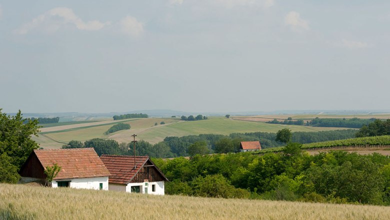 Weinviertler Landschaft, © Michael Himml Landschaft mit Feldern, Bäumen und zwei kleinen Häusern mit roten Dächern.