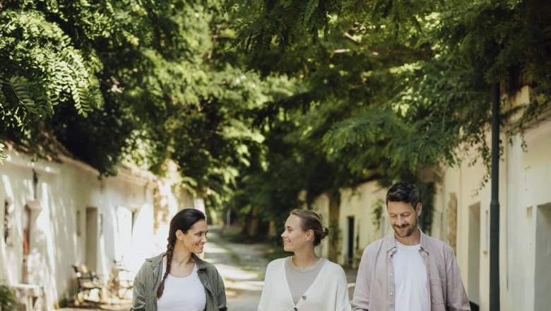 Poysdorf Radyweg, © Weinviertel Tourismus / Sophie Menegaldo Three people are walking along a tree-lined path in Poysdorf.