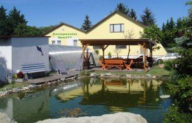 Aussenansicht, © © Pension Sport 71 Außenansicht einer gelben Gästepension mit Teich und Pavillon.