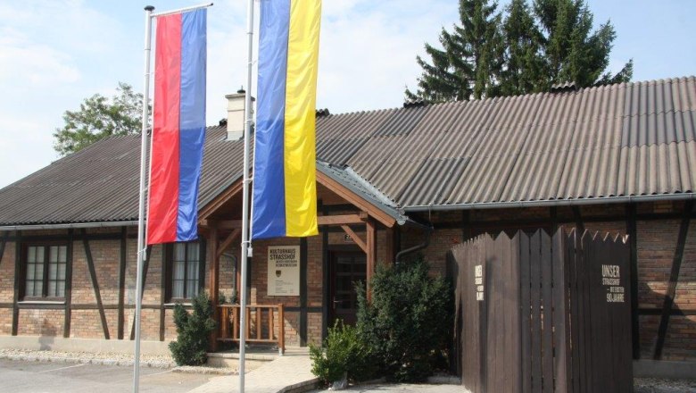 Heimatmuseum, © Gemeinde Strasshof Eingang des Heimatmuseums Strasshof mit zwei Fahnenmasten und einem Holzzaun.