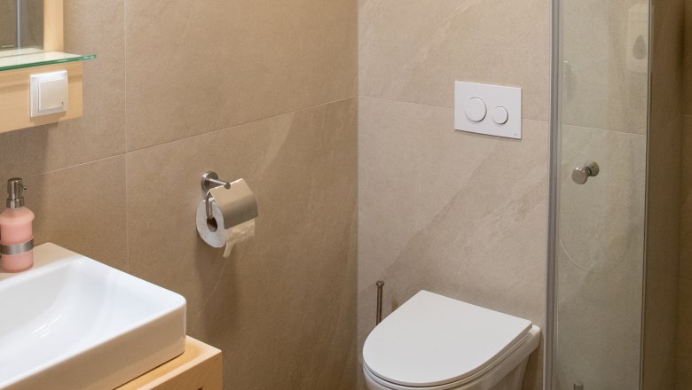 Badezimmer, © Nadine Beles Modernes Badezimmer mit Waschbecken, Toilette und Duschkabine.