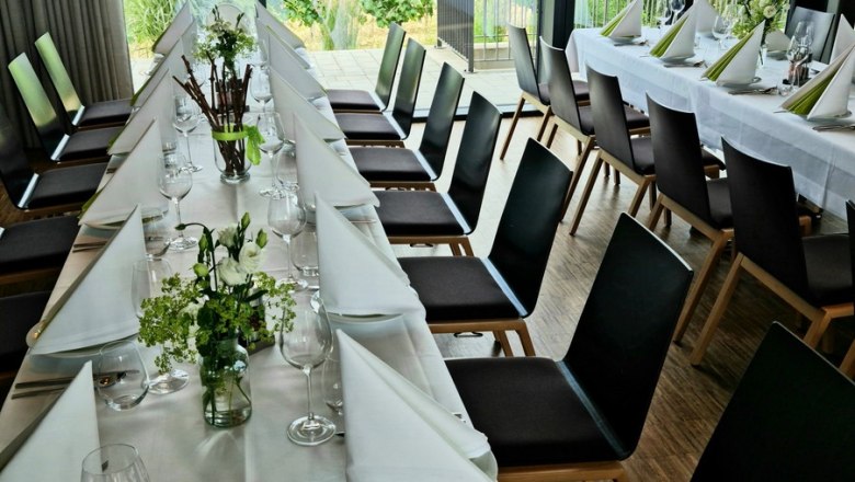 Feste feiern im W4, © W4 Eleganter gedeckter Tisch in einem Raum mit Blick auf Weinberge.