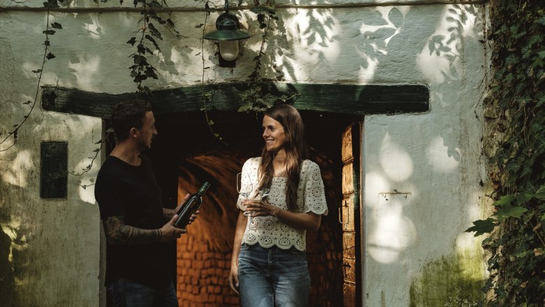 Wine cellar lane Schindergasse, © Weinviertel Tourismus GmbH / Michael Reidinger Two people are standing in front of a wine cellar on Schindergasse in Herrnbaumgarten.