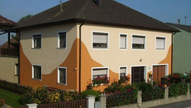 Hausansicht, © Fam. Völker Zweistöckiges Haus mit orange-beiger Fassade und Garten.