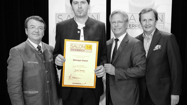 Salon 2014 Auszeichnung, © Fam. Dietzl Vier Männer in Anzügen halten eine Auszeichnung mit der Aufschrift 'Salon 14 Österreich Wein' in die Kamera.