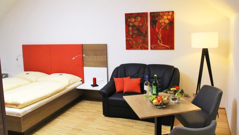 Ferienwohnung, © Wolfgang Rieder Gemütliches Zimmer mit Doppelbett, Sofa, Tisch und Stehlampe.