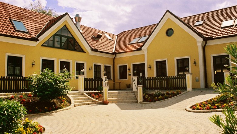 Wine tavern, © Fam. Groiss Yellow building with red tiled roofs and garden.