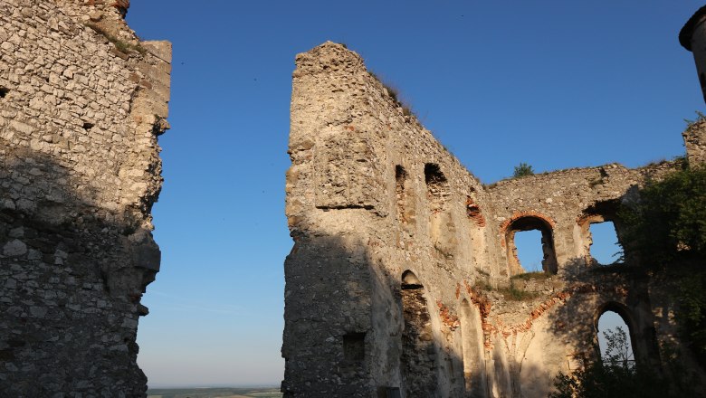 Burgruine Falkenstein, © Weinort Falkenstein Ruinen der Burgruine Falkenstein bei Sonnenuntergang mit blauem Himmel.