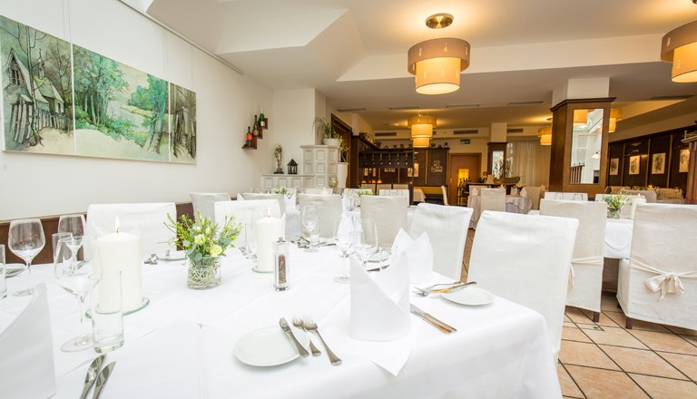 Winter Garden Restaurant, © flotographix The winter garden with a laid table and white chairs.