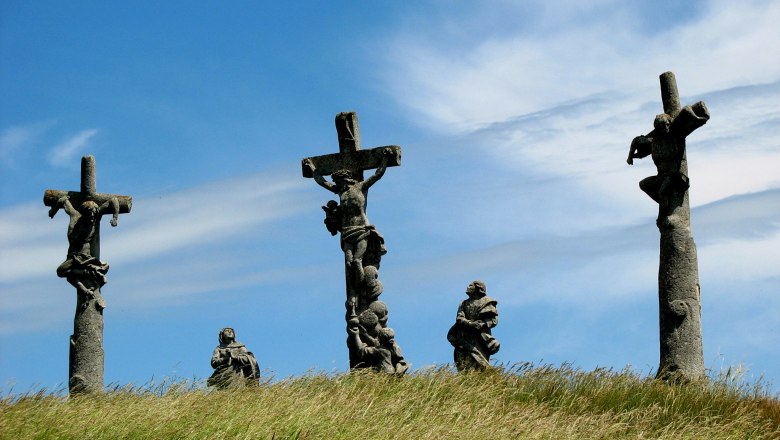 Calvary Pillersdorf, © Franz Tröthan Three crosses with figures on a hill under a blue sky.