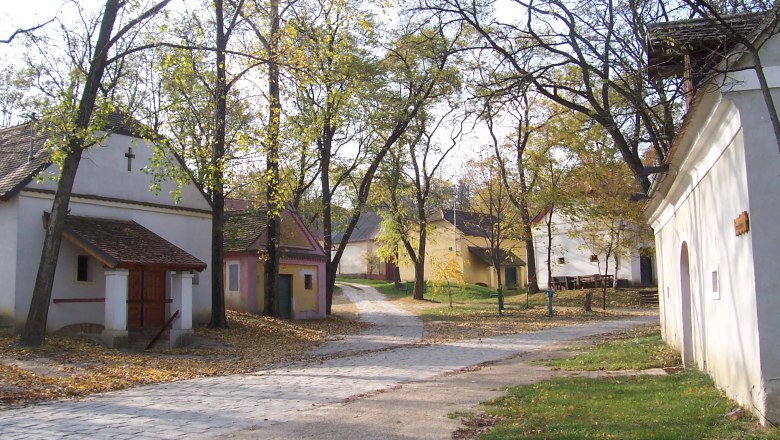 Loamgrui in Unterstinkenbrunn, © Gemeinde Unterstinkenbrunn Ein ruhiger Dorfplatz mit kleinen, traditionellen Gebäuden und Bäumen im Herbst.