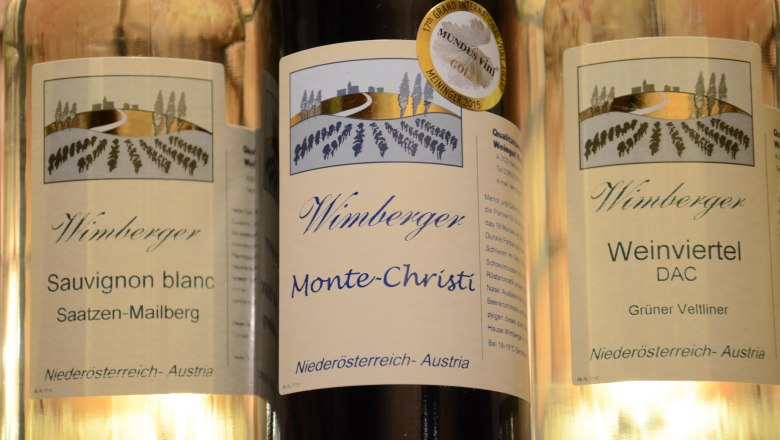 Wimberger Weine, © Weingut Wimberger Drei Weinflaschen der Marke Wimberger mit Etiketten für Sauvignon Blanc, Monte-Christi und Weinviertel DAC.