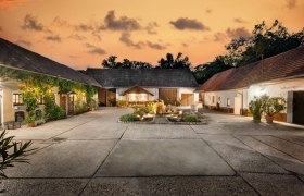 Gemütlicher Innenhof, © Martin Sommer Ein malerischer Hof bei Sonnenuntergang mit beleuchteten Gebäuden und einem zentralen Brunnen.