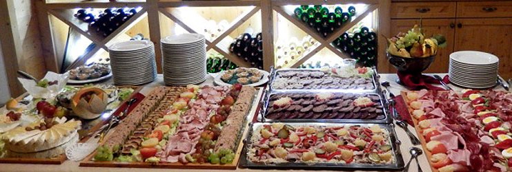 Delicacy, © Fam. Böswirth Buffet with various meat and cheese platters in front of a wine rack.