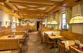 Heurigenlokal, © Weingut Deutsch Innenansicht eines traditionellen Heurigenlokals mit Holzmöbeln und gemütlicher Beleuchtung.