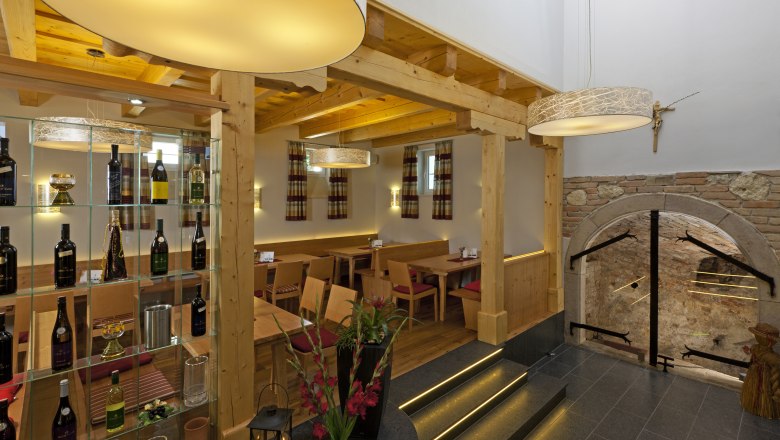 Viticulture Reisinger, © Wögerer Interior view of a wine tavern with wooden furniture, wine rack and decorative lamps.
