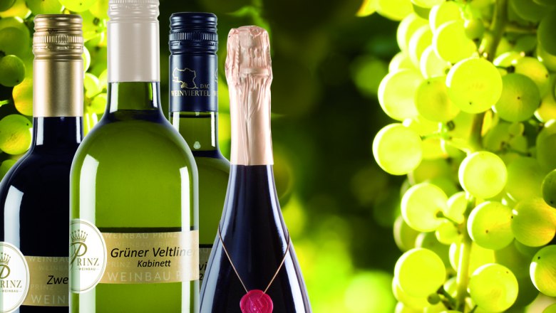 Wine from the Weinviertel, © Weinbau Prinz Wine bottles against a background of green grapes.