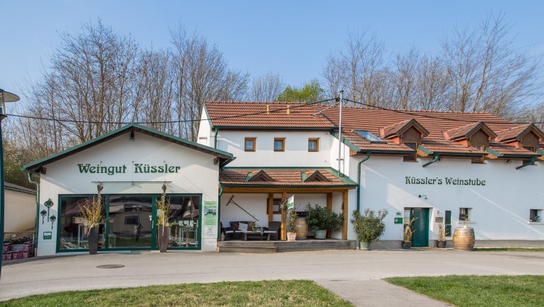 Winery Küssler, © Winzerhof Küssler Weingut Küssler with wine bar and terrace, surrounded by trees.