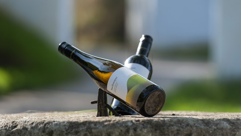 Weingut Buchmayer, © Michael Himml Zwei Weinflaschen auf einem Stein, eine liegt schräg, die andere steht im Hintergrund.