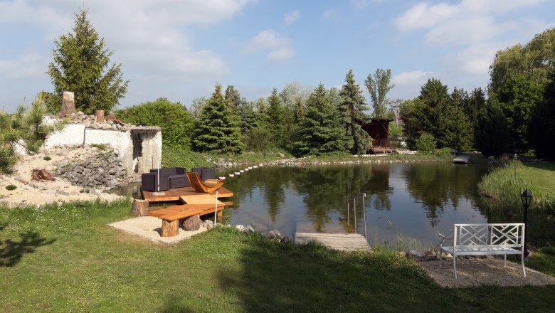 Teichanlage, © Leopold Pluschkowitz Ein idyllischer Gartenteich mit Sitzgelegenheiten und umgebender Vegetation.