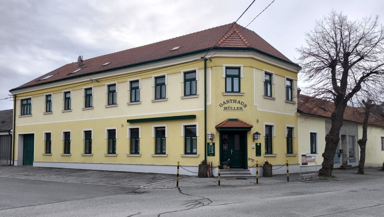 Gasthaus Müller, © Weinviertel Tourismus Gelbes zweistöckiges Gebäude mit der Aufschrift 'Gasthaus Müller'.