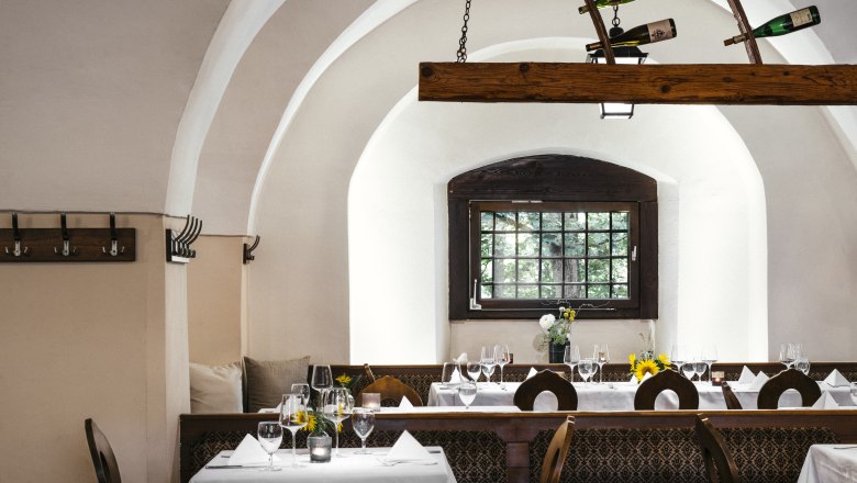 Das Ambiente ist außergewöhnlich, © Niederösterreich Werbung/Julius Hirtzberger Elegantes Restaurant mit gewölbten Decken, gedeckten Tischen und Weinflaschen-Dekoration.