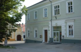 Jugendhaus, © K-Haus Ein zweistöckiges, hellgrünes Gebäude mit der Aufschrift 'Haus' über der Tür.