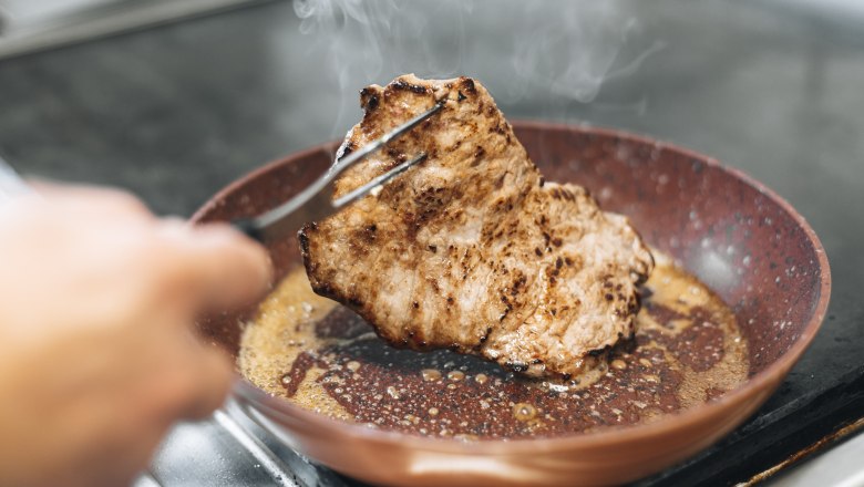 Abwechslungsreiche Spezialitätenwochen, © Niederösterreich Werbung/David Schreiber Ein Stück Fleisch wird in einer Pfanne gebraten.