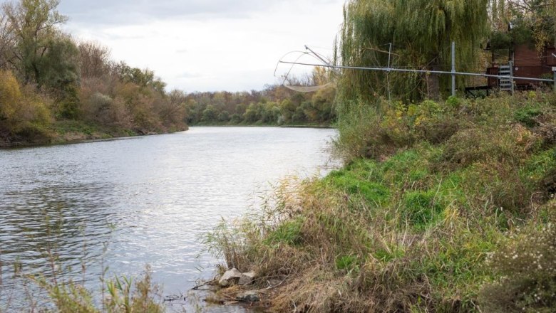 March, © Anita Thiebet Fotografie Flusslandschaft mit Bäumen und grünem Ufer.