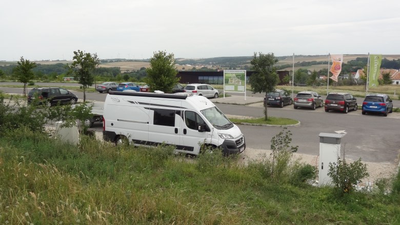 Motorhome parking space, © Arbo Walenta Motorhome in a parking lot with surrounding landscape.