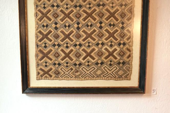 the MERKIMA Gallery, © Doris Hauser Red sofa in front of a framed, patterned work of art on the wall.