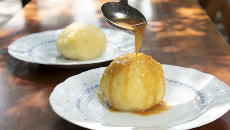 Dumpling dish, © Ben Leitner A dumpling on a plate is covered with sauce, another dumpling in the background.