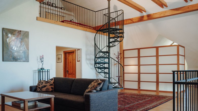 Kellerloft, © Weinakademie Retz Wendeltreppe hinauf zum Schlafbereich, im Vordergrund gemütliche Couch