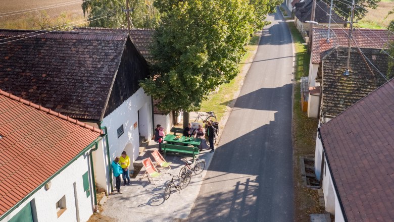 Cellar wellness area Alberndorf, © Initiative Pulkautal / P. Mödl Aerial view of a rural road with people, bicycles and trees.