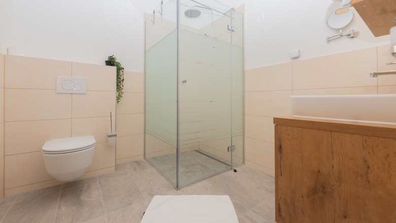 Badezimmer, © Schönfelderhof Modernes Badezimmer mit Dusche, Toilette und Waschbecken.